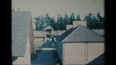 1959: panoramic view of various buildings and stables surrounded by a fortress