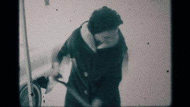 1959: a woman trying to clean the house front and a car parking outside