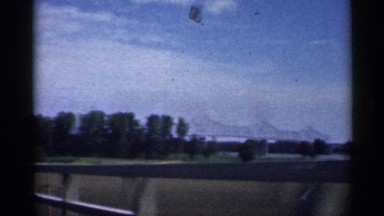 1959: drive in a car the road go to bridge long distance view for the mountain