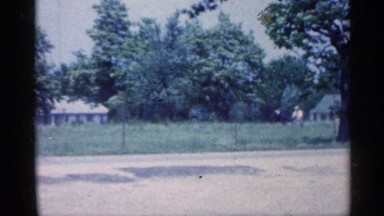 1959: a man in a yellow shirt in a small single person buggy is being pulled by