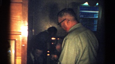 1959: child's are playing inside a house with elder people are socializing