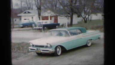 1959: the car is move and the backward and the old lady and boy playing