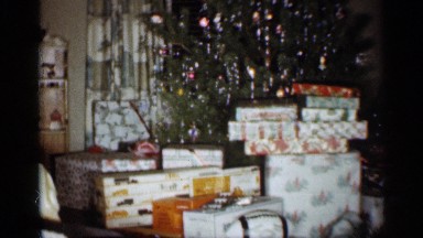 1959: room with many gifts around a tree and a woman sitting in a chair INDIANA