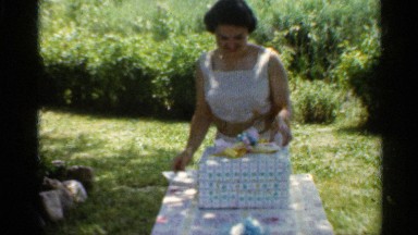 1959: smiling woman opening pretty wrapped gift and card INDIANA