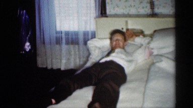 1959: man laying on a bed then boy comes in to get his attention. INDIANA