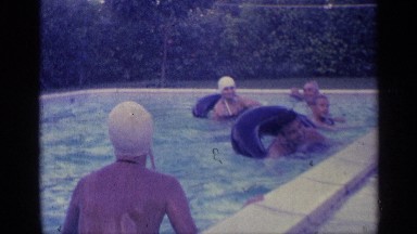 1959: some people are swimming at the swimming pool with tires