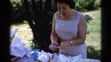 1959: woman unwrapping and showing a collection of glass objects INDIANA