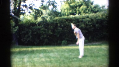 1959: two men play badminton as team on lawn surrounded with tall hedges INDIANA
