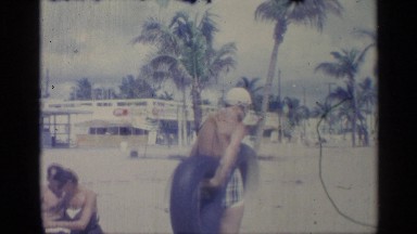 1959: a father and his child playing on the beach INDIANA