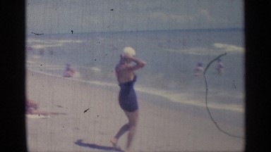 1959: the lady stand in beach and reach the sea dive sea using air filled car