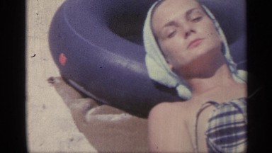 1959: women wearing bikini laying on the beach sunbathing. INDIANA
