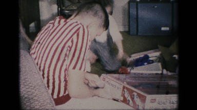 1959: children playing with toys on christmas morning while mother helps.
