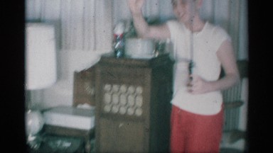 1959: a woman inside her house and taking an equipment it looks like cordless