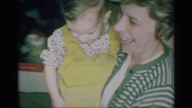 1959: mother carries her daughter and walks through the hall and seated in sofa