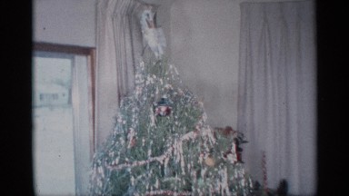 1959: a fully decorated christmas tree, complete with presents and happy child