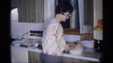 1959: one person plays, while another prepares food and puts it on a table