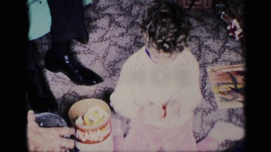 1959: a child is playing with her toys indoor in a room beside her open toy box