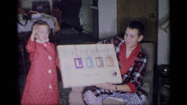 1959: the mother and her kid are inside the home and she showed a board