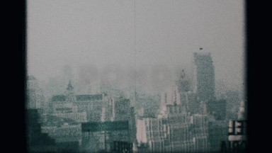 1959: panorama of a hazy city skyline, including vintage building advertisements