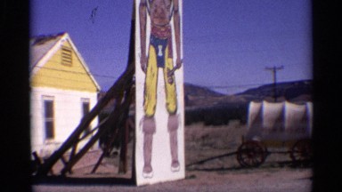 1959: a tall muscular native american man is painted on a wall in a field