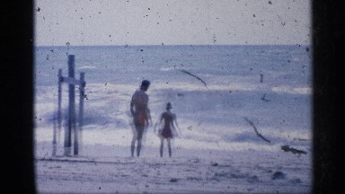 1959: the father and his daughter are playing on the seashore CALIFORNIA