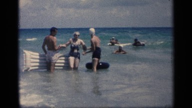 1959: family beach adventure with elder family members with blue ocean water