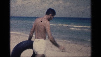 1959: a man at the beach talking the car tube with air and run reach the sea