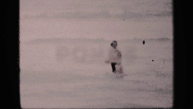 1959: a man and boy played and bath in to the sea the man rise is hand signal