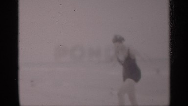 1959: a lady and some people sit beach and talk each other after the lady