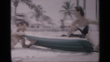 1959: a group of adults on the beach who are sunbathing and enjoying each other