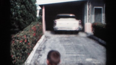 1959: a child walks around the front yard of a house in the summer. CALIFORNIA