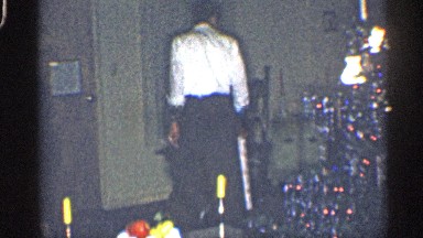 1959: a dad at in the living room during christmas holidays holding a present