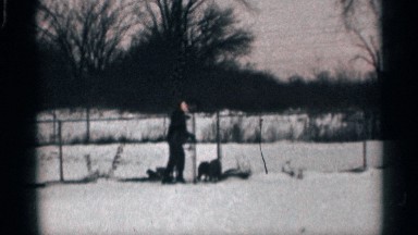 1959: a man plays outside in the snowy weather with his two dogs CALIFORNIA
