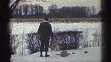 1959: a man at the snow area and two dogs also with him and the dogs are running