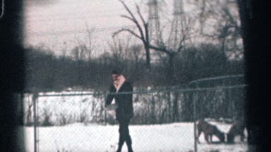 1959: man running towards camera after feeding dogs in the snow CALIFORNIA