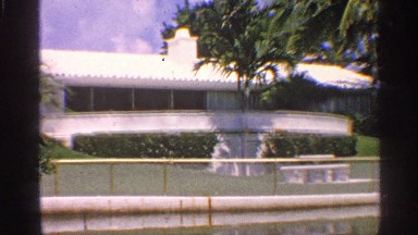 1959: a building is shown its fully covered by trees and plants