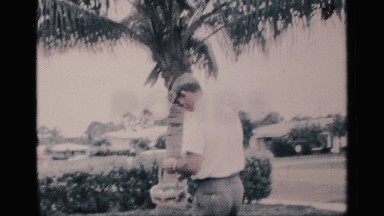 1959: smiling man searches for easter eggs in the front yard FLORIDA