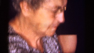 1959: An Elderly Woman Wearing Glasses Surrounded by People in Florida