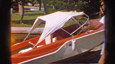 1959: men launch a small boat into the water. FLORIDA