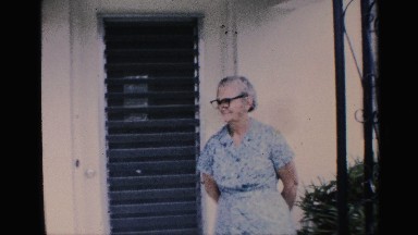 1959: elderly woman standing outside a home and a child waving FLORIDA