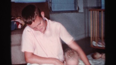 1959: a boy playing with small infant by making it to stand on his legs FLORIDA