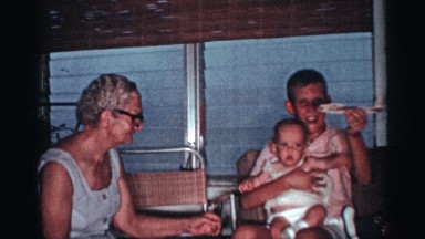 1959: a young boy sits down holding his baby sister while he is flying