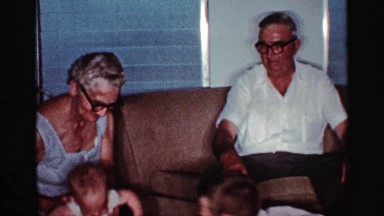 1959: an older man and woman are playing with a boy and a baby girl