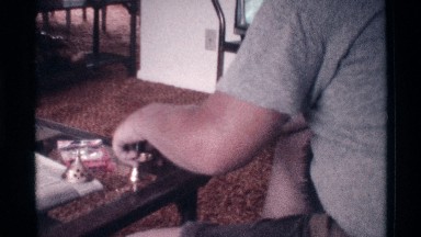 1973: Man Puts Incense Into Incense Burner on Coffee Table
