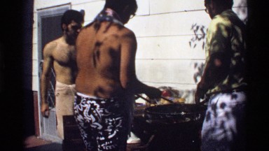 1978: group of adults gathered around the barbeque enjoying each others company