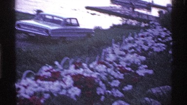 1969: a sedan is parked by a flower garden, located near the water. OHIO