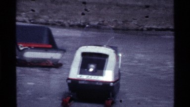 1969: sled and snowmobile on a frozen body of water OHIO