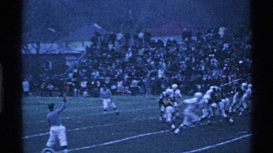 1969: fans look, as football players pile on a player and the ball gets hurled