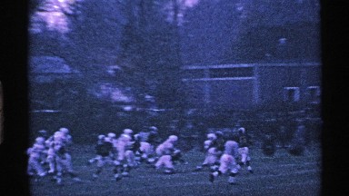 1969: people standing watching a football game. OHIO