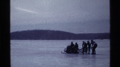 1969: group of people using sleds to glide over frozen body of water OHIO